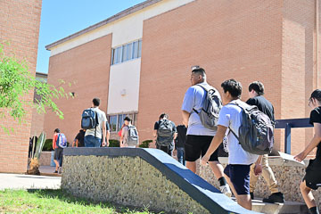 Students climb the stairs to enter on their first day back.