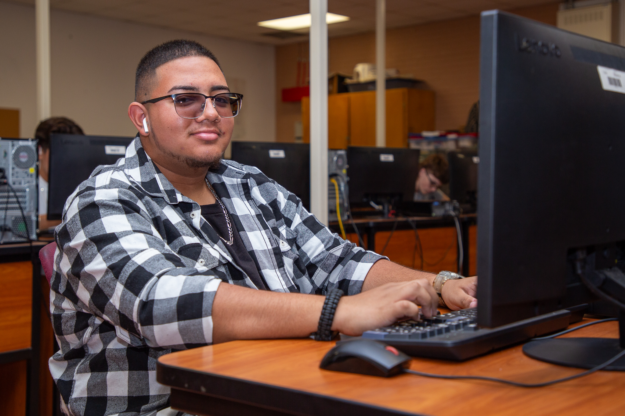 A teen boy works on a computer