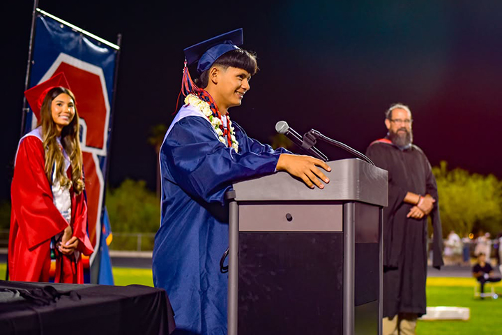 A graduate addresses his class from the stage
