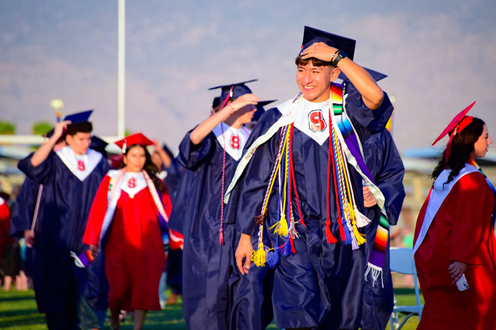 Graduates walk across the field