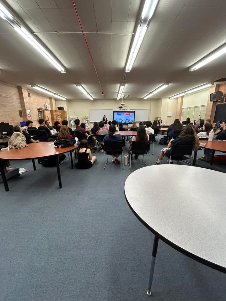 Students sit in a classroom watching a presentation