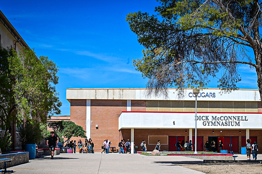 Students walk around outside the school building