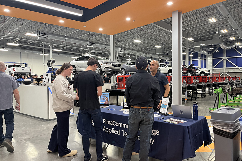 Students stand around a table talking