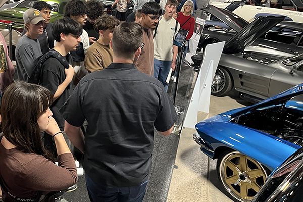 Students look at classic cars on display