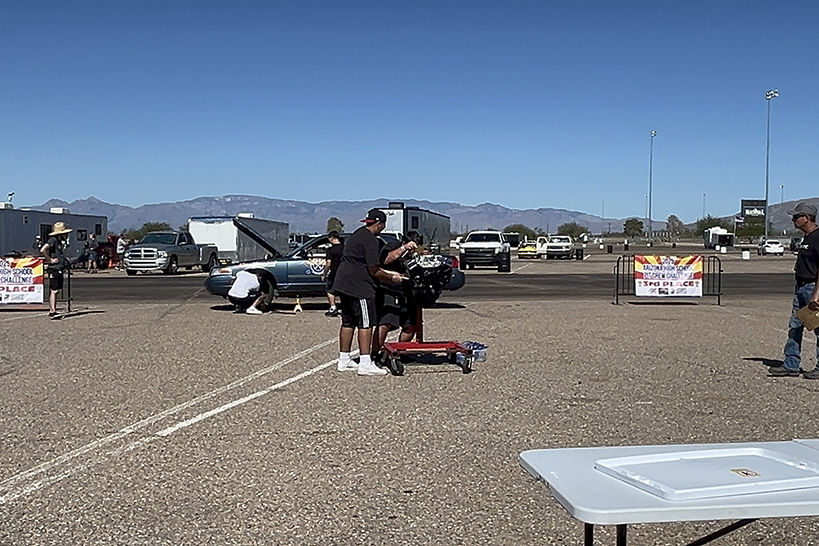 Teen boys work on a car outside
