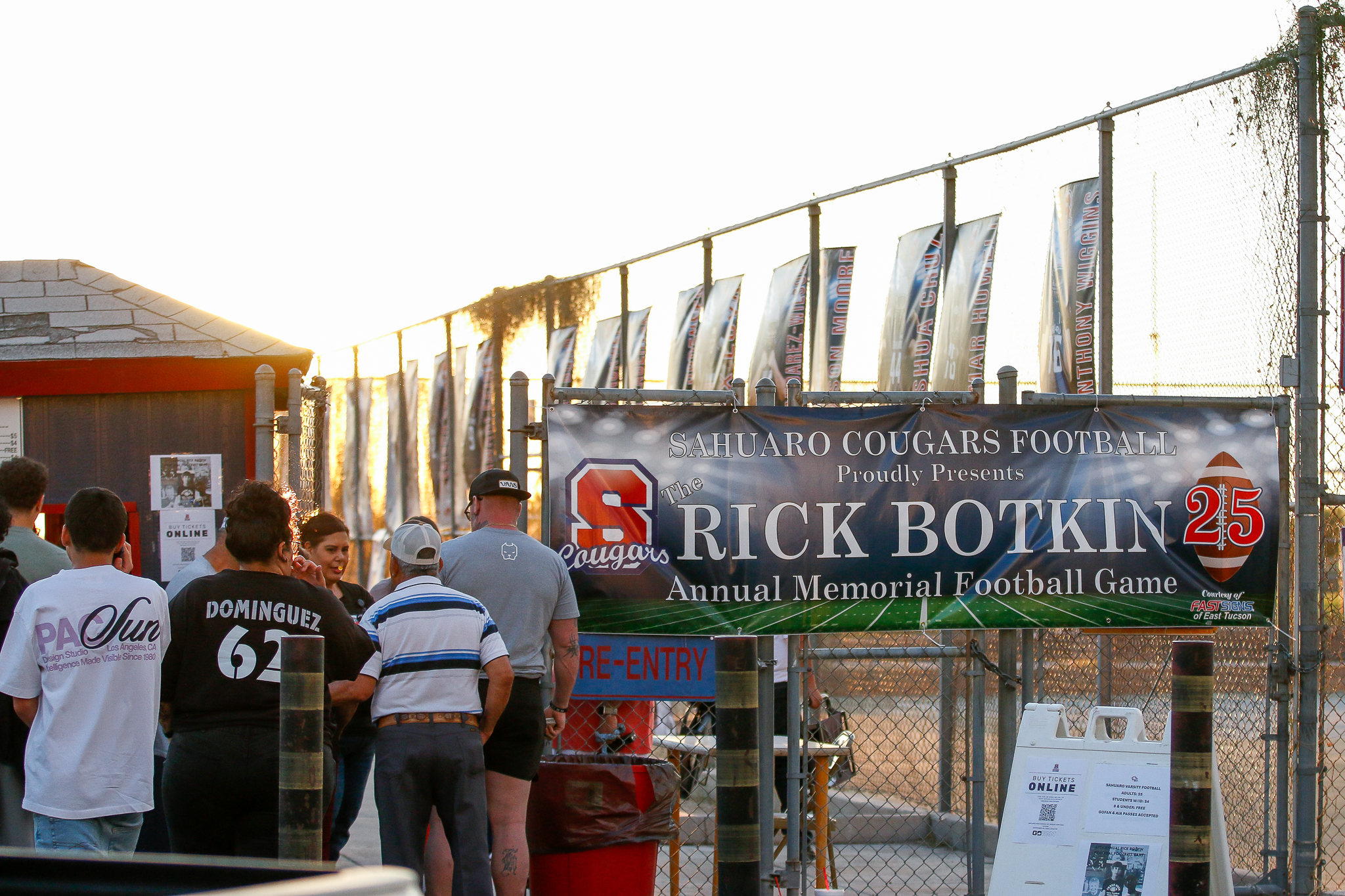 Sahuaro fans walk into the stadium past the Rick Botkin Annual Memorial Football Game banner