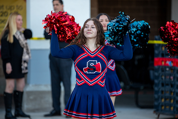 A Sahuaro cheerleader raises her red and blue pompoms